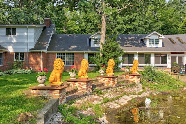 4705 Weiss Rd, Frankenmuth, MI 48734 - view of front of house with a shingled roof, a chimney, brick siding, and a front lawn