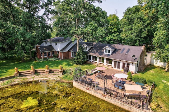 back of house featuring a patio area and a lawn