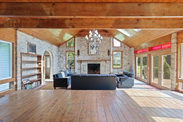 4705 Weiss Rd, Frankenmuth, MI 48734 - living room featuring wood-type flooring, high vaulted ceiling, a chandelier, arched walkways, and a large fireplace
