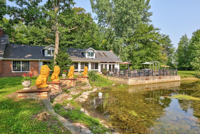 4705 Weiss Rd, Frankenmuth, MI 48734 - back of property with a water view, brick siding, a chimney, and a shingled roof