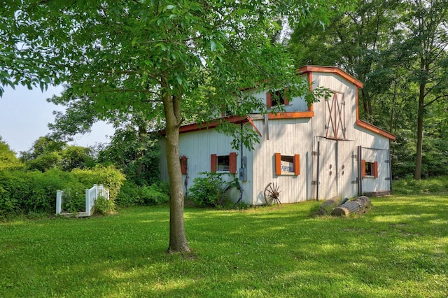 view of property exterior featuring a lawn and an outdoor structure