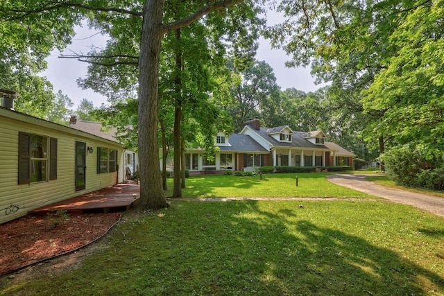 view of front of house with a wooden deck and a front lawn