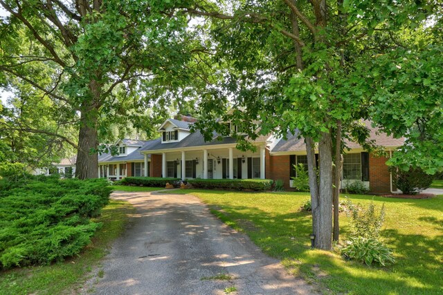 4705 Weiss Rd, Frankenmuth, MI 48734 - view of front of property with brick siding, a front lawn, a porch, driveway, and a shingled roof
