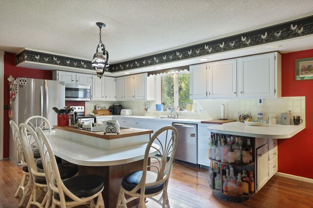 4705 Weiss Rd, Frankenmuth, MI 48734 - kitchen with stainless steel appliances, dark wood-type flooring, tasteful backsplash, light countertops, and a textured ceiling