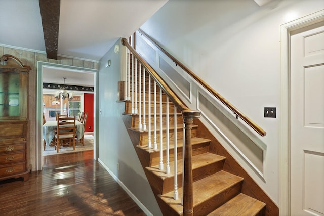 staircase with hardwood / wood-style floors, crown molding, beamed ceiling, and a chandelier