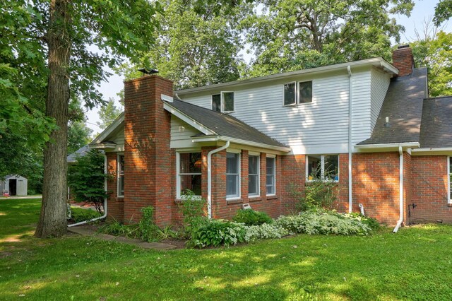 4705 Weiss Rd, Frankenmuth, MI 48734 - view of side of home with a chimney, a yard, and brick siding