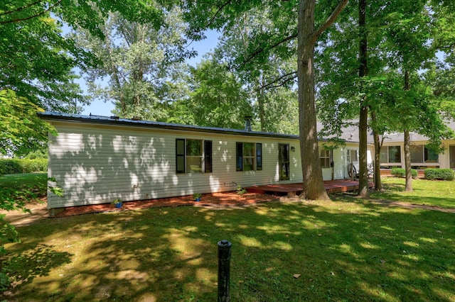 single story home featuring a deck and a front lawn