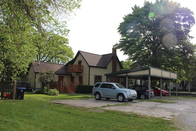 tudor house featuring a carport and a front yard