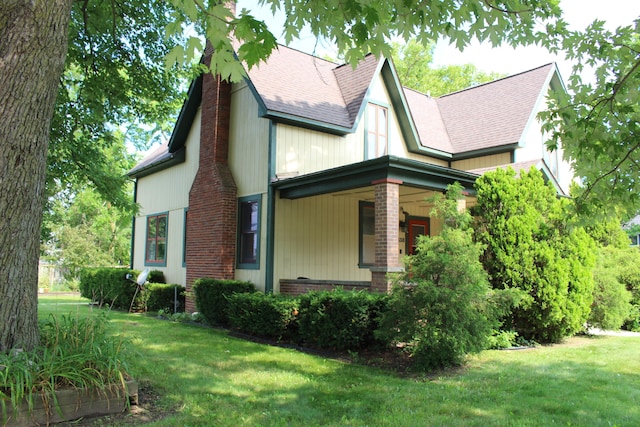 view of property exterior featuring covered porch and a yard