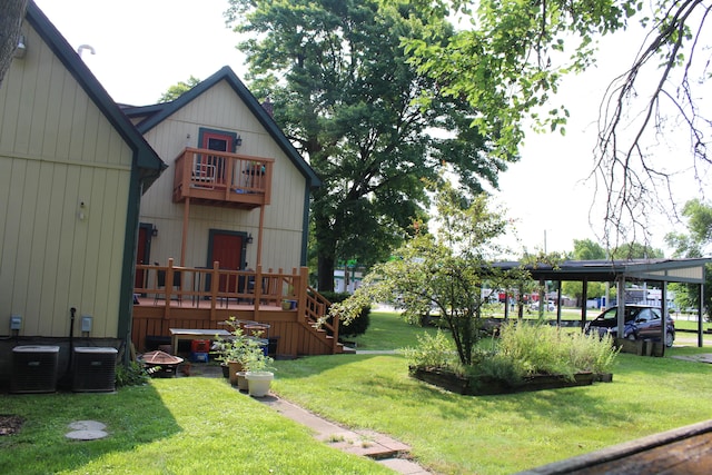 view of yard featuring a balcony, a carport, and central air condition unit