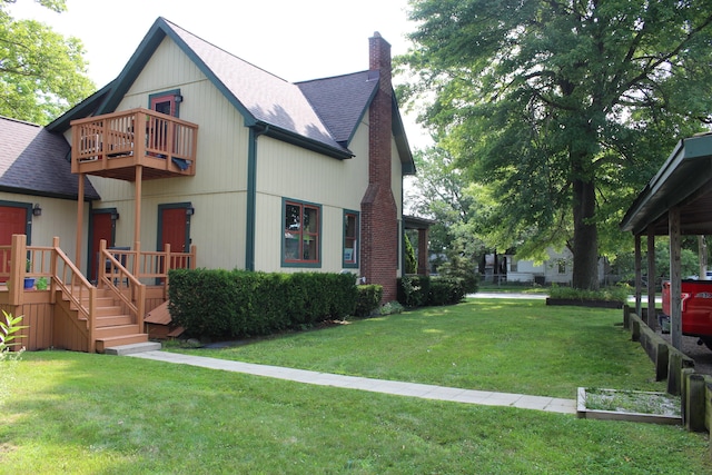 view of front of home with a balcony and a front yard