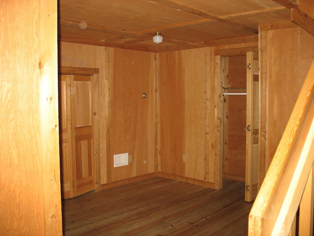 unfurnished room featuring wood walls, hardwood / wood-style floors, and wooden ceiling