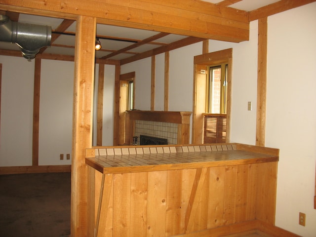 bar featuring a tile fireplace and tile countertops