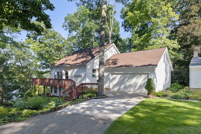 view of front facade with a front yard, a garage, and a deck