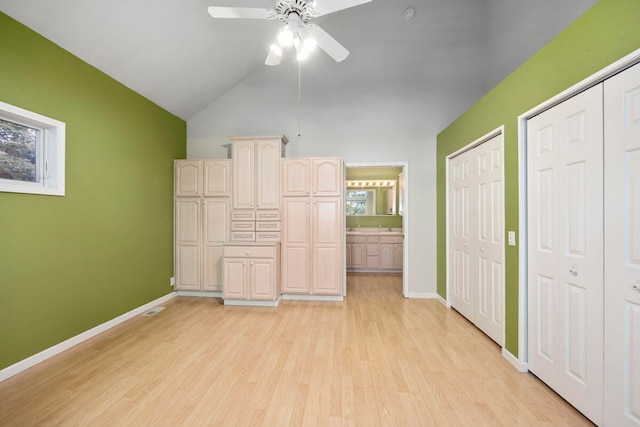 kitchen with lofted ceiling, ceiling fan, a wealth of natural light, light brown cabinetry, and light hardwood / wood-style floors