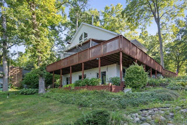 back of property with a lawn and a wooden deck