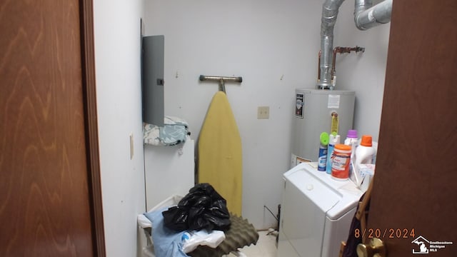 washroom with tile patterned floors, washer and dryer, and water heater