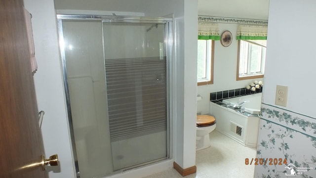 bathroom featuring plus walk in shower and toilet