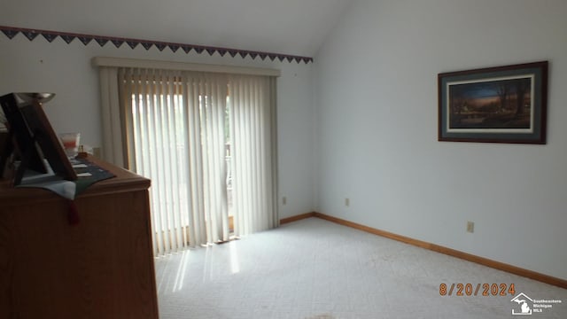 carpeted spare room with lofted ceiling