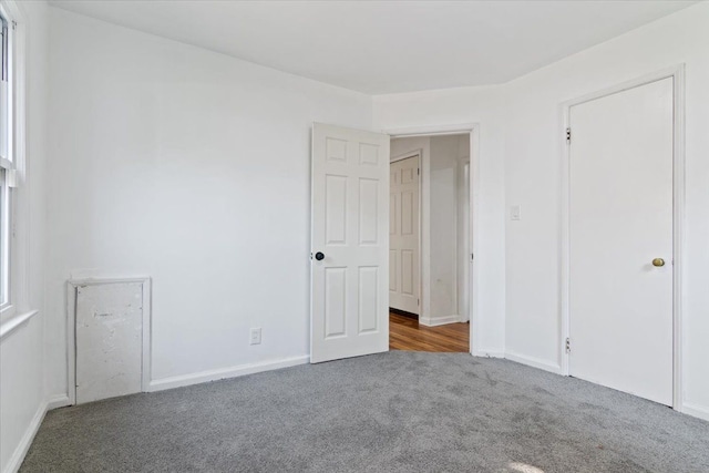 unfurnished bedroom with dark colored carpet