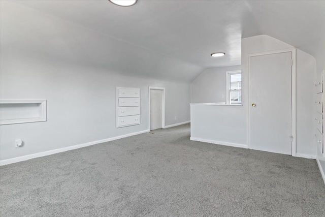 bonus room with carpet flooring and vaulted ceiling