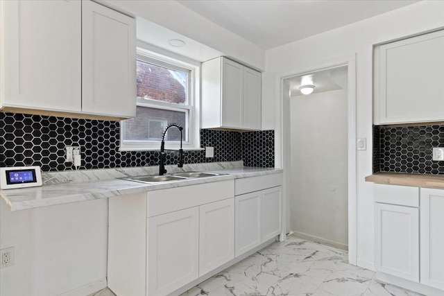 kitchen featuring white cabinets, sink, and tasteful backsplash