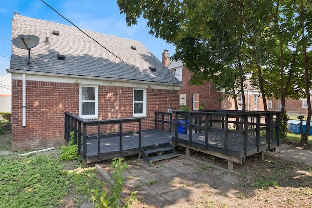 rear view of property featuring a wooden deck