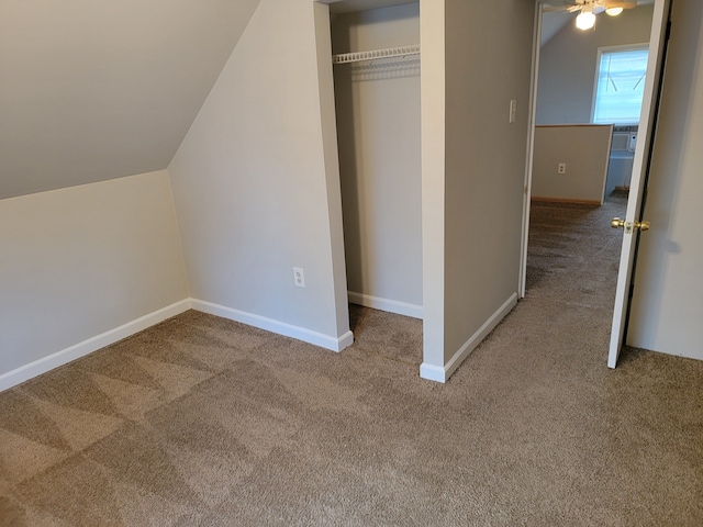 unfurnished bedroom with carpet flooring, a closet, and vaulted ceiling