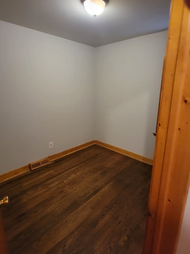 unfurnished room featuring dark wood-type flooring