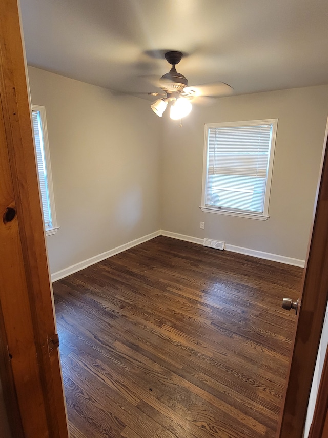 spare room featuring dark hardwood / wood-style flooring and ceiling fan