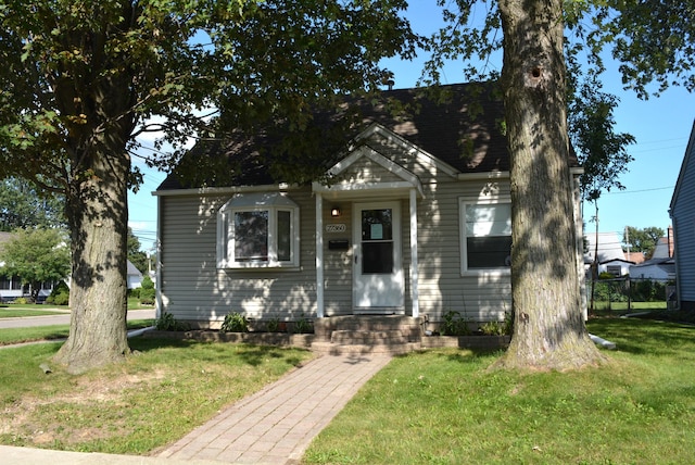 bungalow-style home with a front yard