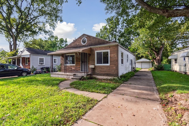 bungalow featuring a garage, an outdoor structure, and a front yard