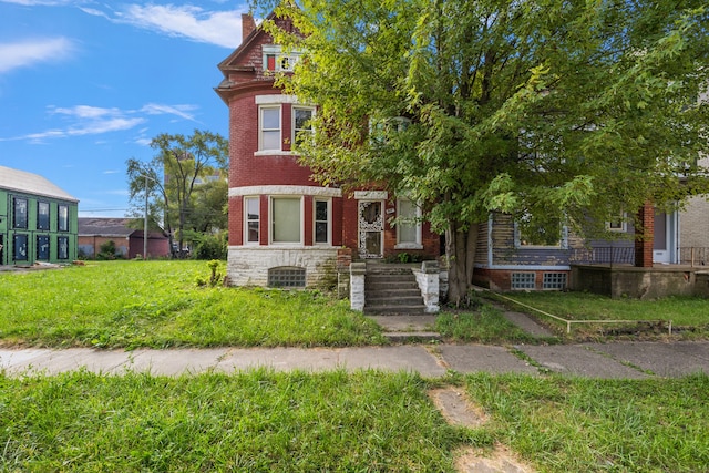 414 Horton St, Detroit, MI 48202 - view of front of house featuring brick siding, a chimney, and a front lawn