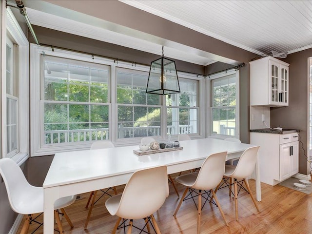 dining area featuring crown molding and light wood-type flooring