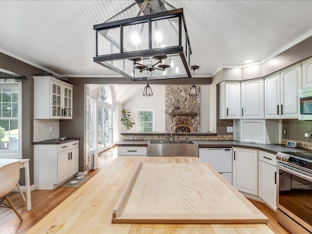 kitchen with white cabinets, decorative light fixtures, stainless steel appliances, and sink