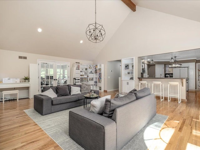 living room with a chandelier, beam ceiling, high vaulted ceiling, and light hardwood / wood-style flooring