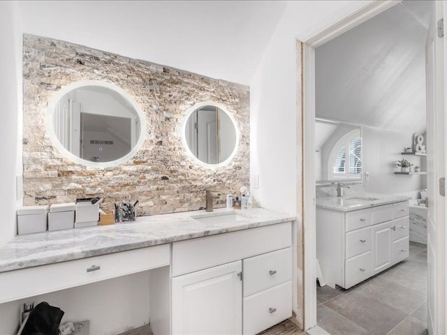 bathroom featuring tile patterned floors, vanity, and vaulted ceiling