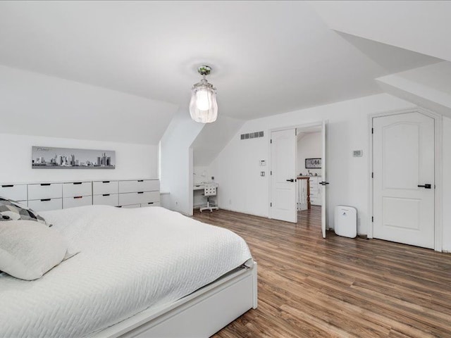 bedroom with wood-type flooring and vaulted ceiling