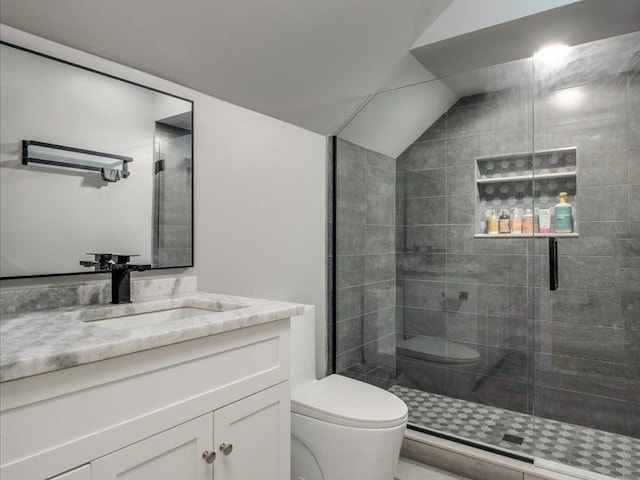 bathroom with vanity, toilet, lofted ceiling, and walk in shower