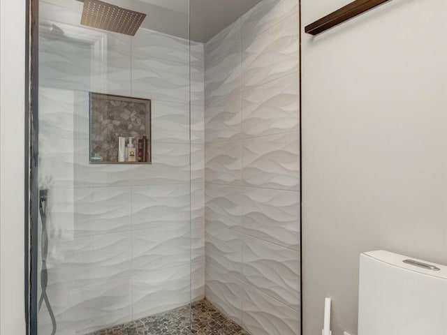 bathroom with tiled shower and toilet