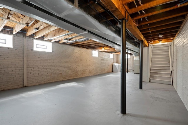 basement with washer / dryer and brick wall