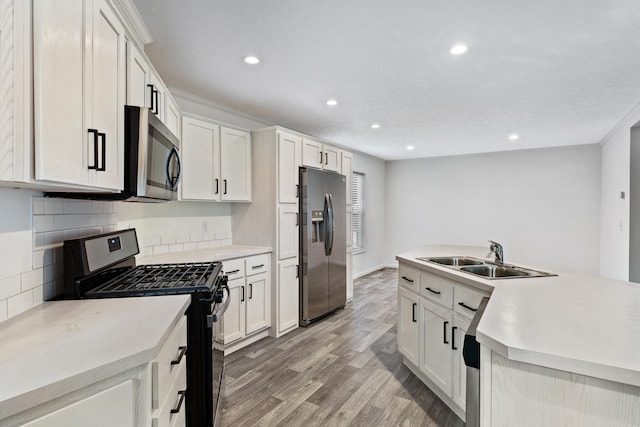 kitchen featuring stainless steel appliances, white cabinetry, and sink