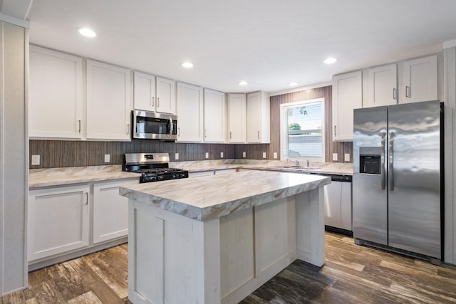 kitchen with white cabinets, dark hardwood / wood-style flooring, stainless steel appliances, and sink