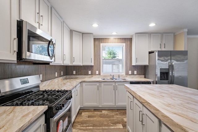 kitchen featuring wood counters, appliances with stainless steel finishes, dark wood-type flooring, sink, and white cabinetry