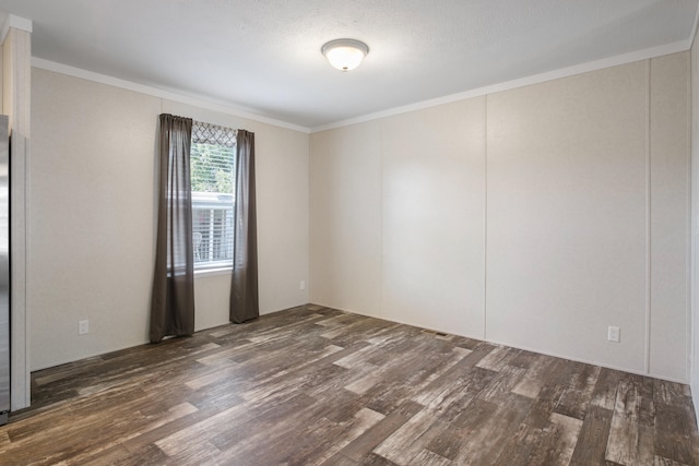 empty room with a textured ceiling, dark hardwood / wood-style flooring, and ornamental molding