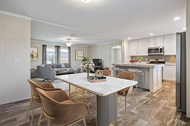 kitchen with a breakfast bar area, white cabinetry, a kitchen island, and stainless steel appliances