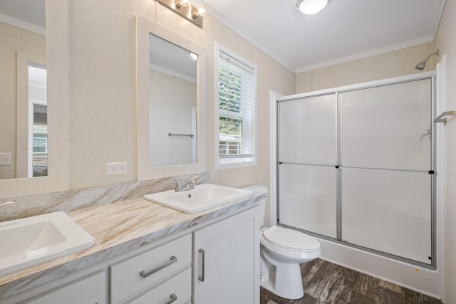 bathroom with crown molding, an enclosed shower, toilet, vanity, and hardwood / wood-style flooring