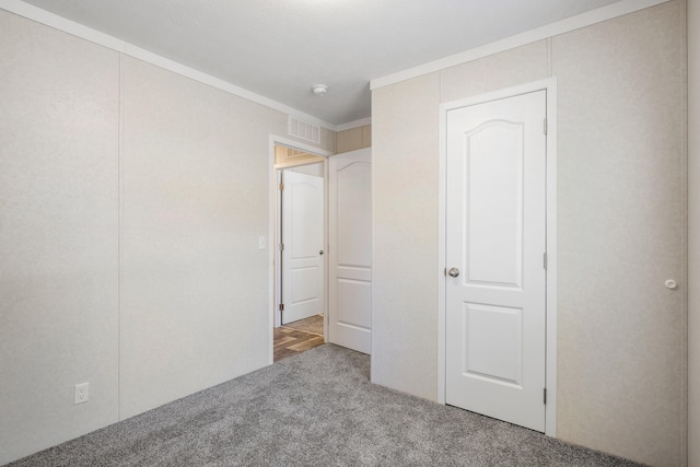 unfurnished bedroom featuring carpet and crown molding