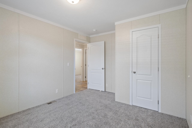 unfurnished bedroom featuring carpet and ornamental molding