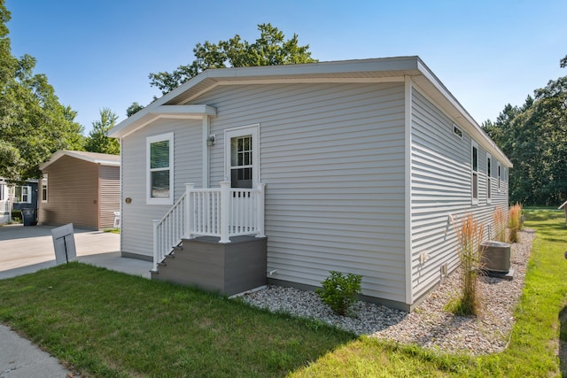 exterior space featuring central AC and a front lawn